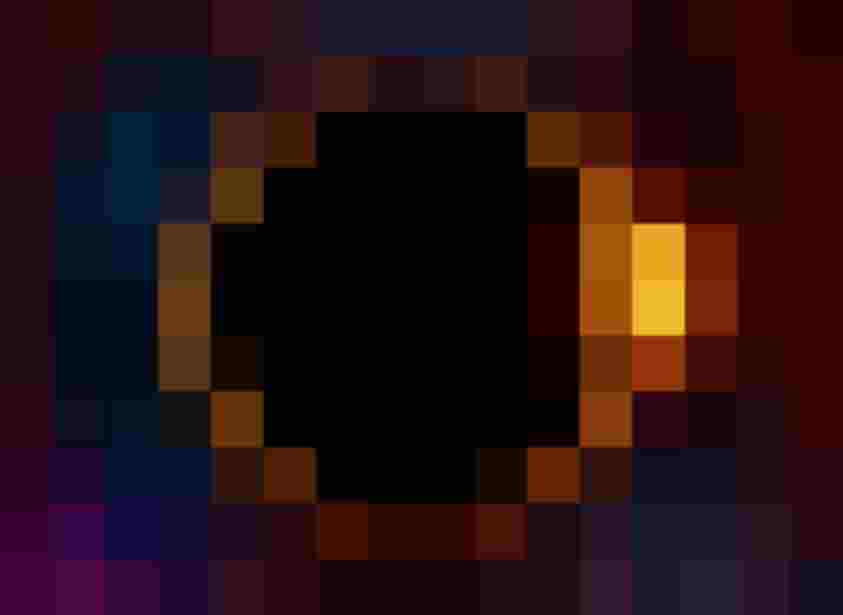 Sonnenfinsternis mit leuchtendem Sonnenrand und farbigem Sternenhimmel im Hintergrund