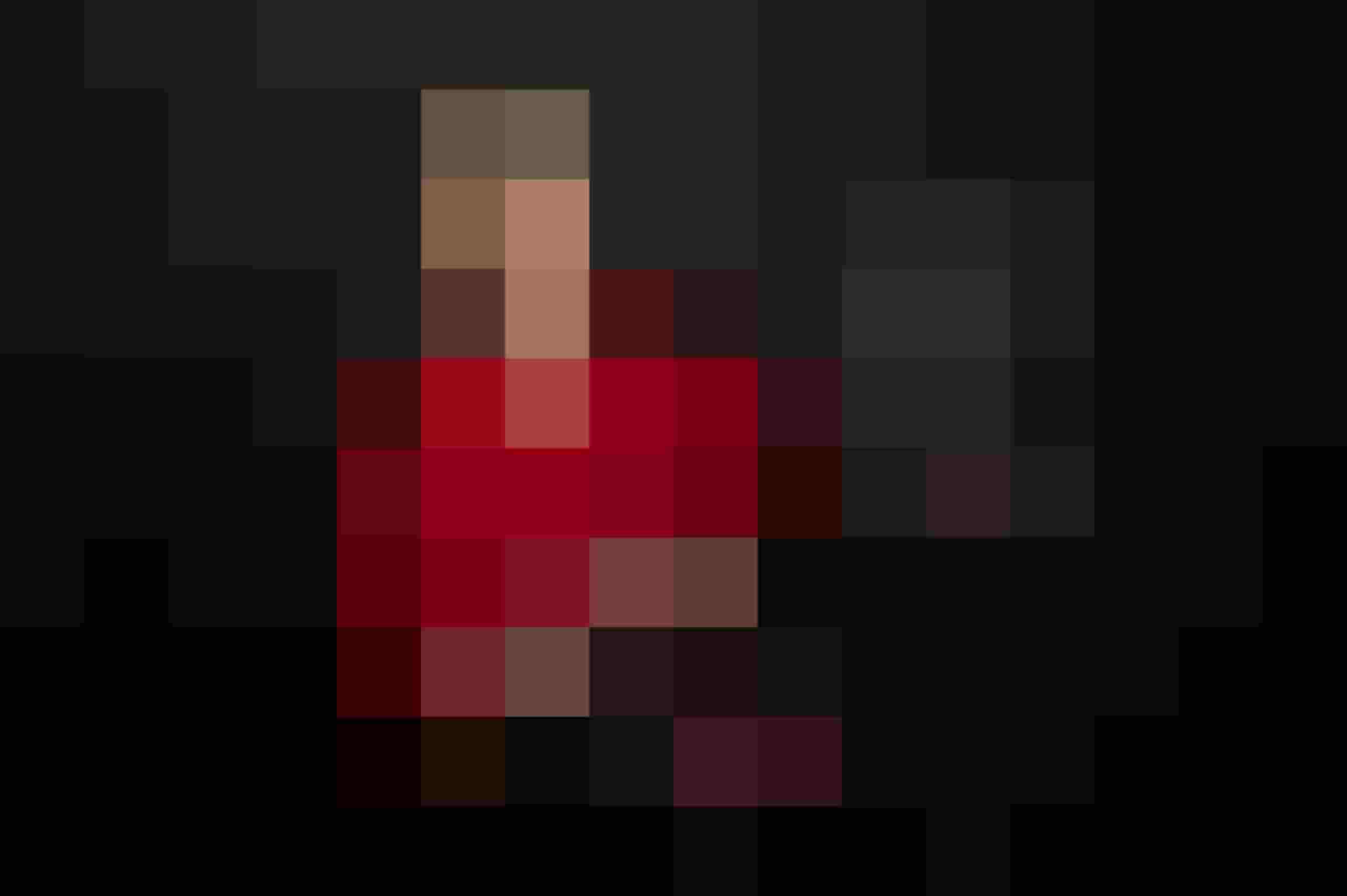 Frau mit rotem Shirt und Laptop vor schwarzem Hintergrund Autorin Liebesromane